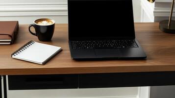 modern office desk with sleek black laptop, cup of coffee, and notepad photo