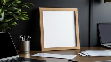 Mockup of a blank poster on a desk with a laptop and a plant photo