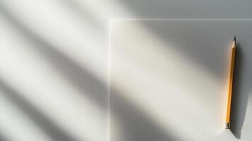 A pencil and a piece of paper on a white surface photo