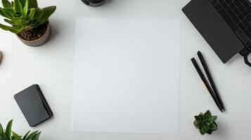 clean workspace featuring blank sheet of paper surrounded by plants and stationery photo