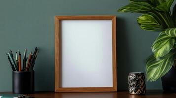 Empty wooden frame on desk with plants and stationery photo