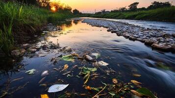 Polluted river with toxic waste and debris at sunset photo