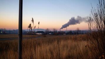 rural village with industrial pollution at sunrise photo
