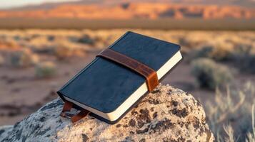 rugged journal resting on rock in desert landscape photo
