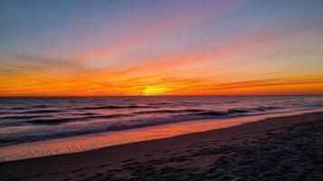 A sunset over the ocean with a beach and sand photo