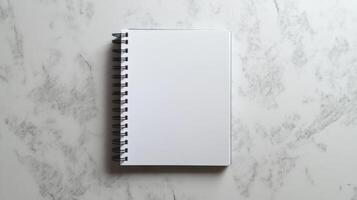 Blank spiral notebook on marble surface for creativity photo