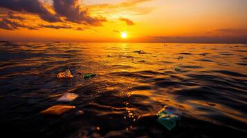 sunset over ocean with plastic waste floating photo