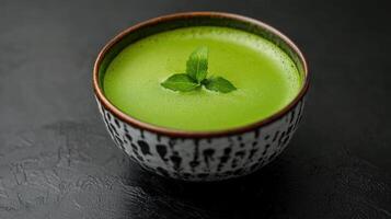 vibrant green tea with matcha powder served in bowl photo
