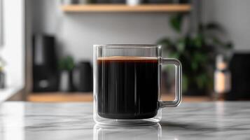 A glass mug of black coffee on a table photo