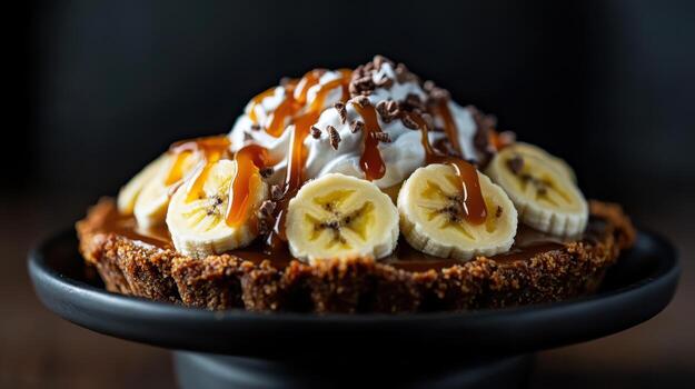 Delicious banoffee pie topped with caramel, bananas, and cream photo