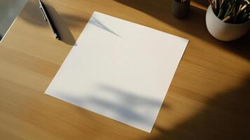 Blank paper on a desk with a pen and plant photo