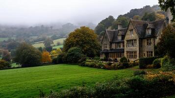 Classic English countryside manor with rolling hills and fog photo