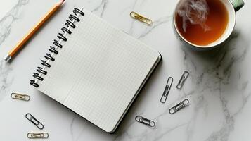 cozy workspace with notebook, pencil, and tea photo