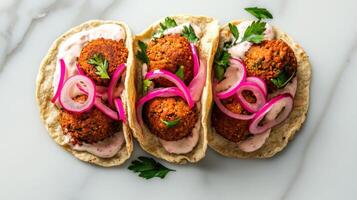 Crispy falafel tacos with pickled onions and tahini sauce photo