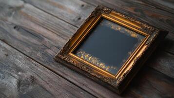 An old gold frame sitting on a wooden table photo