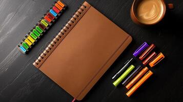 Brown notebook with highlighters and coffee cup photo