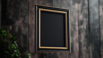 Empty black picture frame with gold accents hanging photo