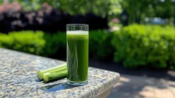 Fresh green detox juice with celery on sunny day photo