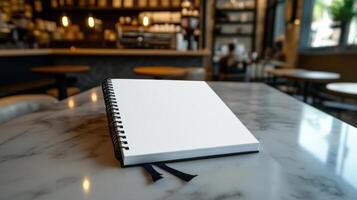 open blank notebook on marble countertop in cafe photo