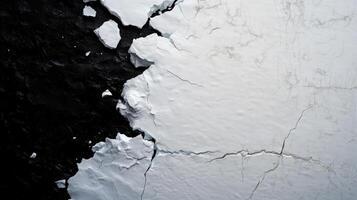 Cracked ice sheet contrasting with dark ocean surface photo