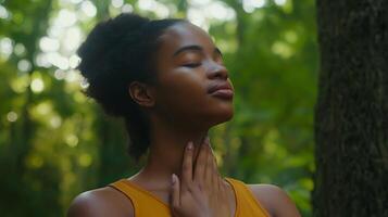 Black Woman Practicing Deep Breathing with Hand on Chest photo