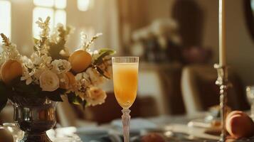 A classic Mimosa cocktail served in a champagne flute, placed on an elegant dining table with floral arrangements and soft golden lighting. photo