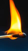 A close-up view of a matchstick in the process of ignition, showcasing the bright yellow flame and intense energy, perfect for concepts of risk and passion. photo