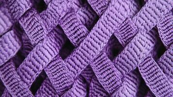 A detailed close-up of a woven purple fabric, showing intricate texture and interlaced fibers, ideal for backgrounds and textile design photo
