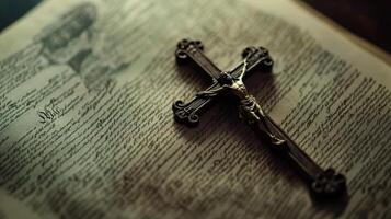 A blackened metal crucifix resting on the pages of an open Bible, representing Christian faith, devotion, and religious symbolism. photo