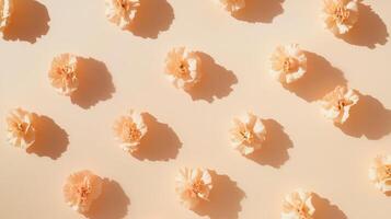 Soft peach flowers scattered on beige background creating a delicate and serene floral pattern in warm light photo