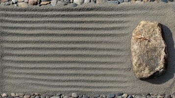 Zen garden with raked sand and a large stone creating a tranquil atmosphere for relaxation and reflection photo