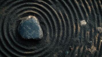 Ripples forming around a stone on a textured sand surface in a serene outdoor setting during daytime photo