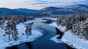 Serene Winter River Landscape Snow Covered Trees and Frozen Water Flowing Through a Mountain Valley photo