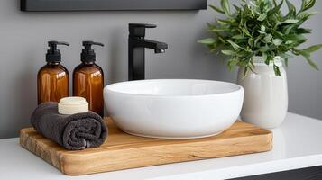 Modern Bathroom Interior Design White Vessel Sink on Wooden Tray with Amber Soap Dispensers and Dark Towel photo