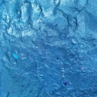 Blue Textured Surface with Embedded Objects and Linear Patterns photo