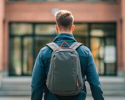 Man with Backpack Facing Building Exterior photo