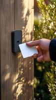 Hand Using Access Card at Electronic Reader on Wooden Door photo