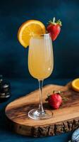 A glass of orange juice with strawberries on top photo