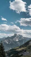 A mountain range with trees and clouds photo
