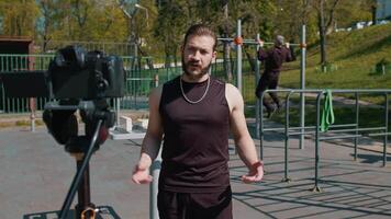 Athletic bodybuilder man records lessons talking to camera, selfie blog vlog for social media video
