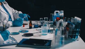 A person in a lab coat and gloves is working on a test tube photo