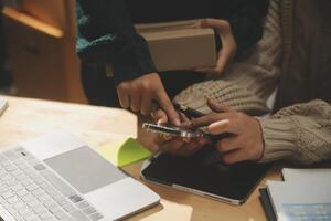 A man and woman are using their cell phones to check out a package photo