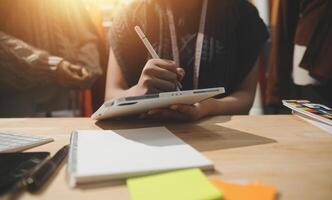 A person is writing on a tablet while sitting at a desk photo