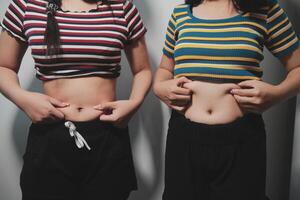 Two women standing next to each other with their stomachs photo