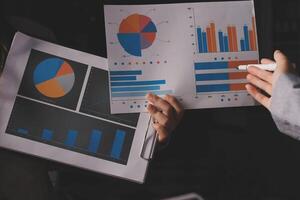 Business people holding papers with graphs and charts photo