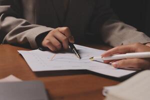 A person is writing on a piece of paper with a pen photo
