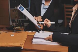Two business women in suits are working on paperwork photo