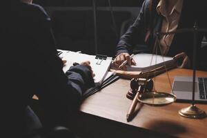 Two business people sitting at a desk with a laptop and papers photo