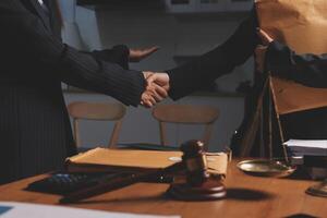 Two business people shaking hands over a desk photo