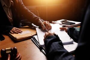 Two people at a desk signing papers photo